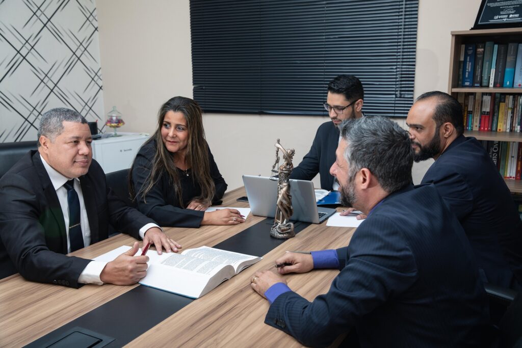 Team of attorneys meeting in a law office to discuss legal strategy, review case documents, and collaborate on client representation.
