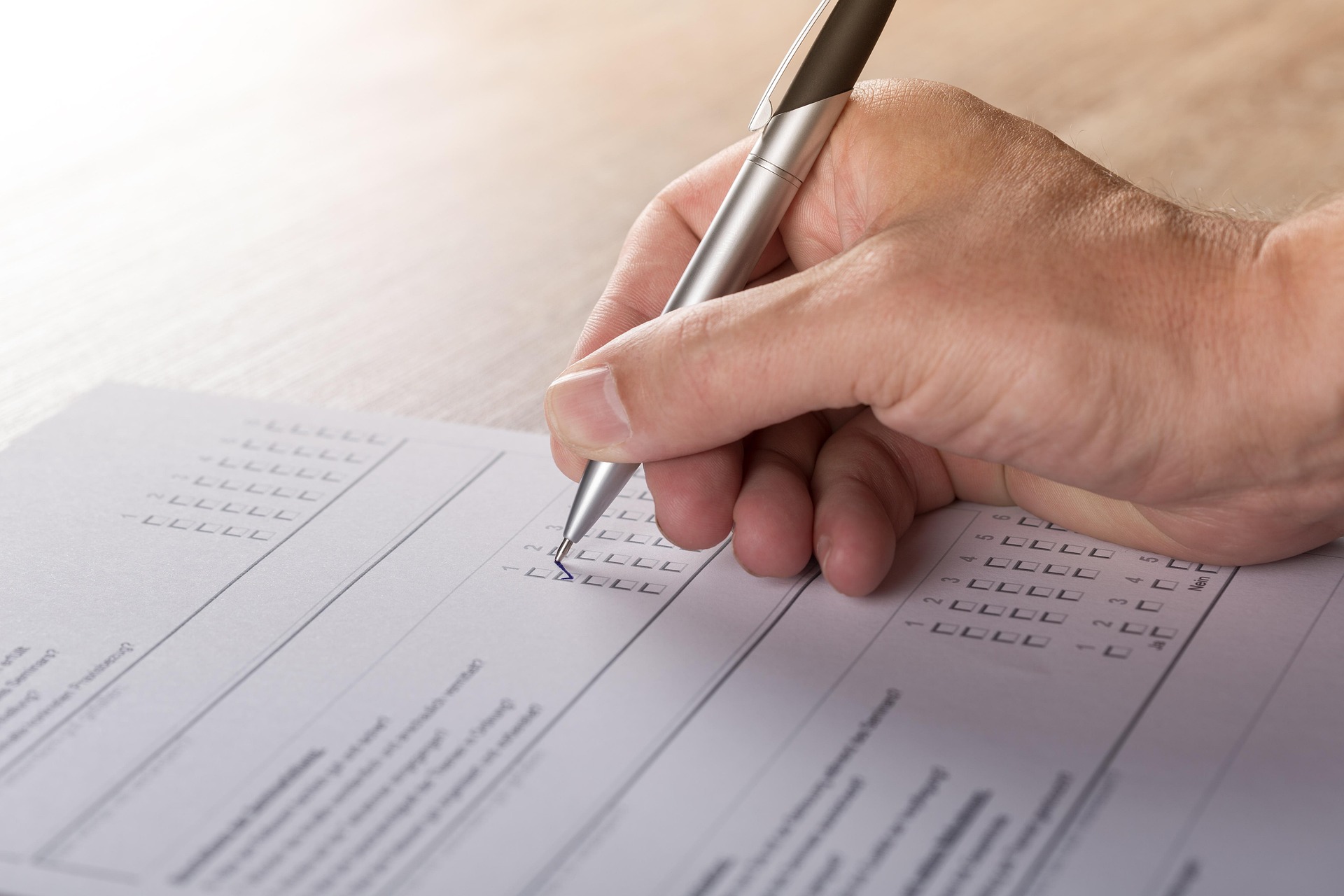 Person completing a legal form by checking boxes with a pen, representing legal paperwork or case documentation.