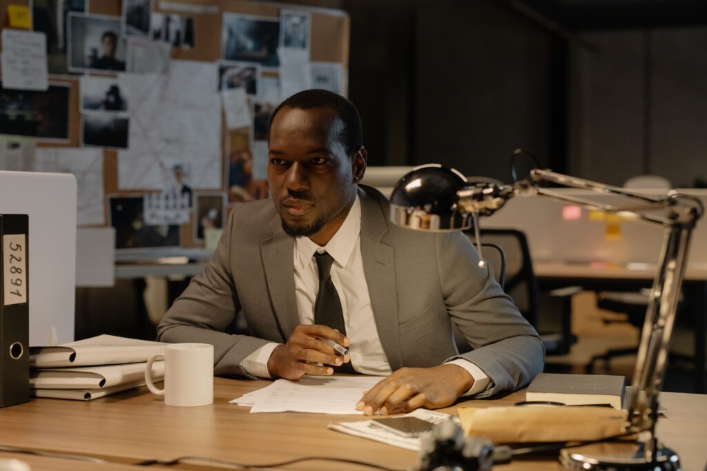 Attorney reviewing case files and evidence at a desk while preparing legal strategy for a client.