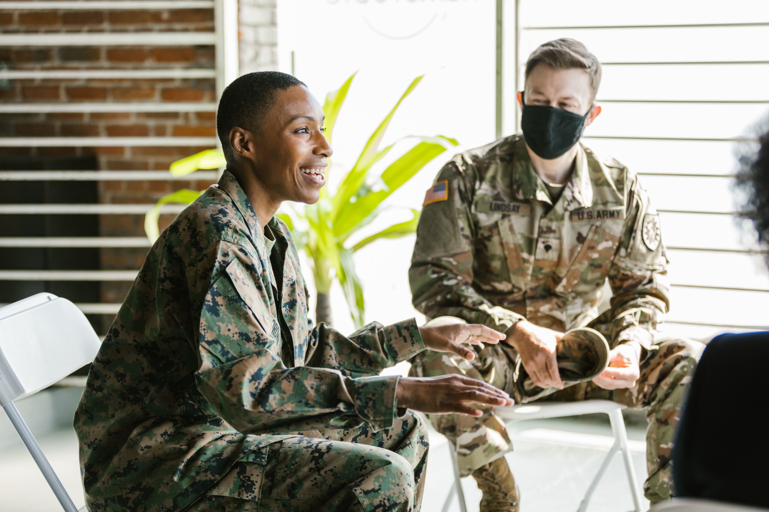 Military service members discussing enlistment and career opportunities during a recruitment meeting.